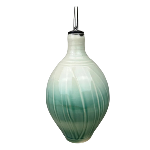 Ceramic oil dispenser with gradient green design on a gray background