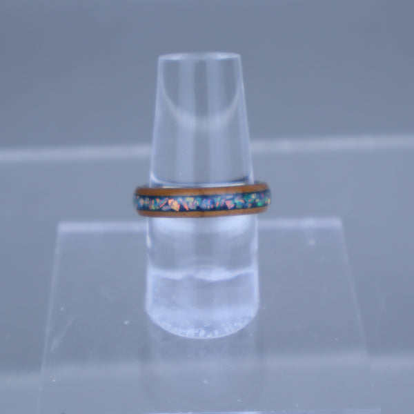 Clear plastic cone-shaped object with a colorful ring on a gray background
