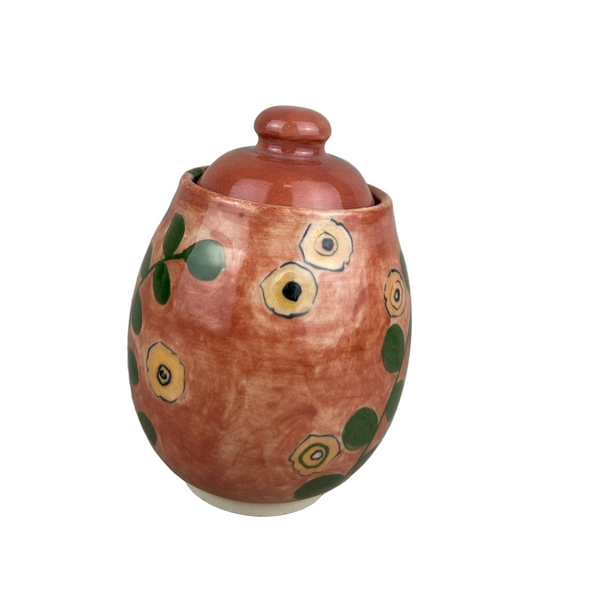 Small ceramic jar with a lid on a gray background