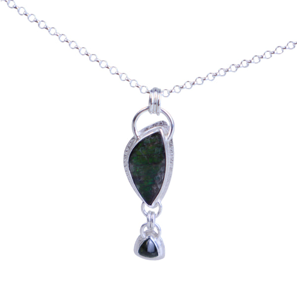 Silver necklace with a green pendant on a light gray background