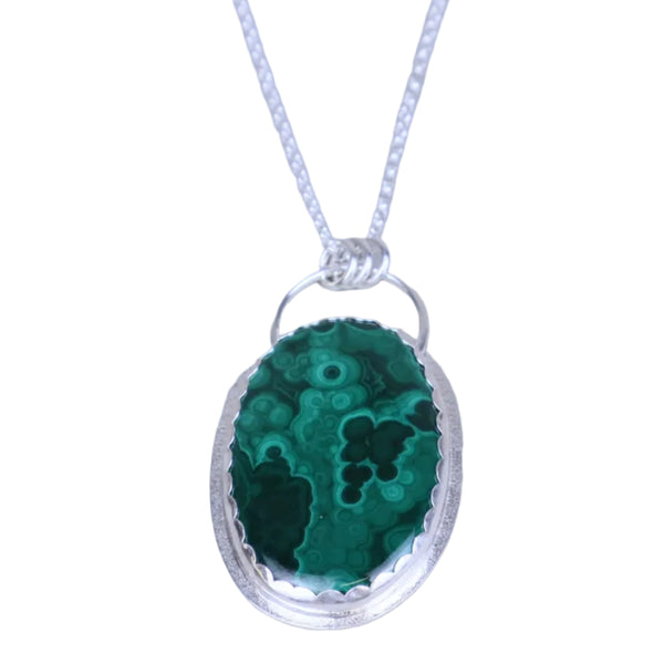 Green stone pendant on a silver chain against a light gray background