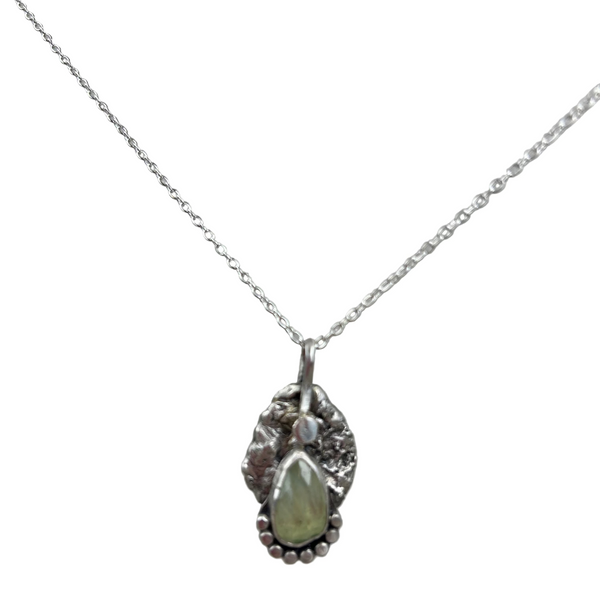 Silver necklace with a pendant featuring a green gemstone on a gray background