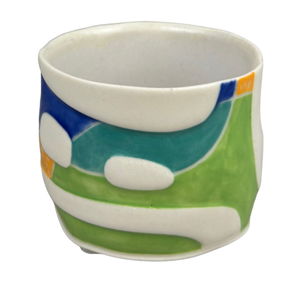 Ceramic cup with colorful abstract design on a gray background