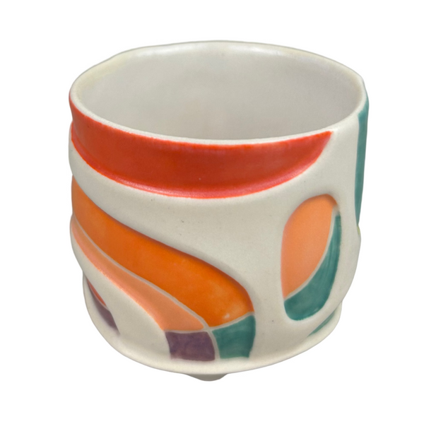 Ceramic cup with colorful abstract design on a gray background