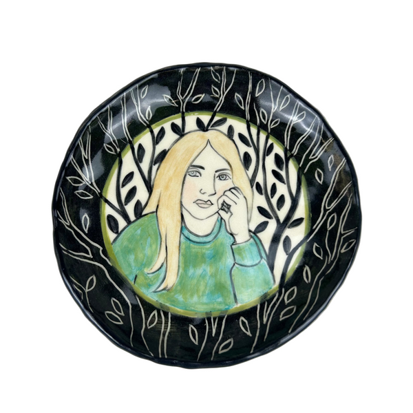 Ceramic plate with a woman's portrait on a black background