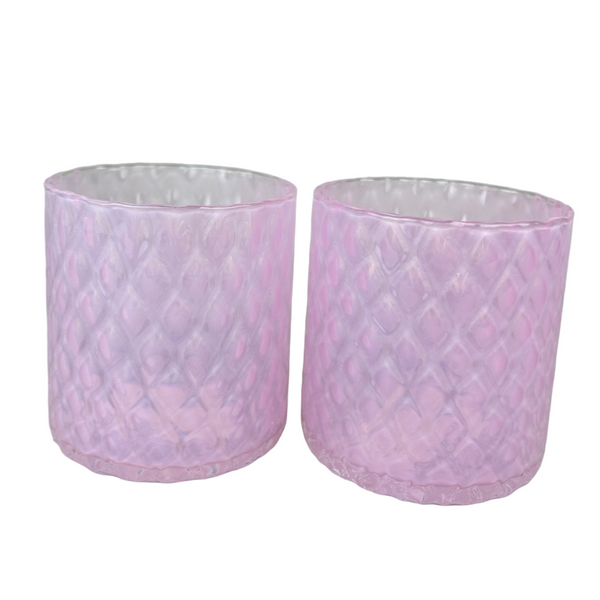 Two pink textured glass tumblers on a light gray background