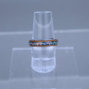 Clear plastic cone-shaped object with a colorful ring on a gray background