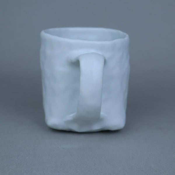 Hand built porcelain cup with folded base
