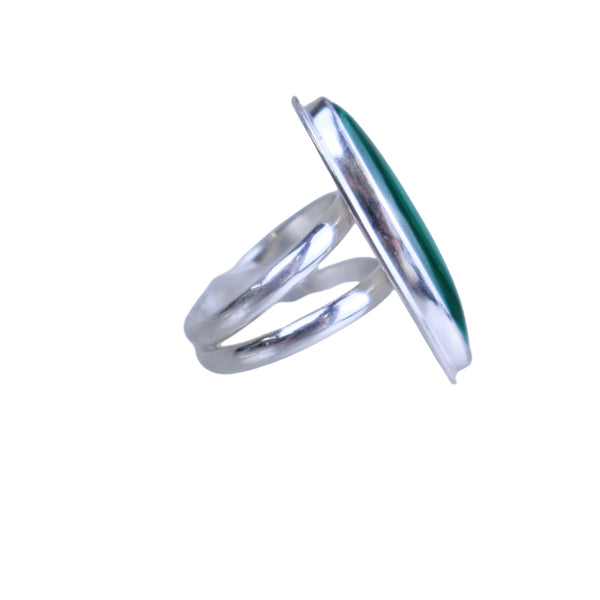 Silver ring with a green stone on a light gray background