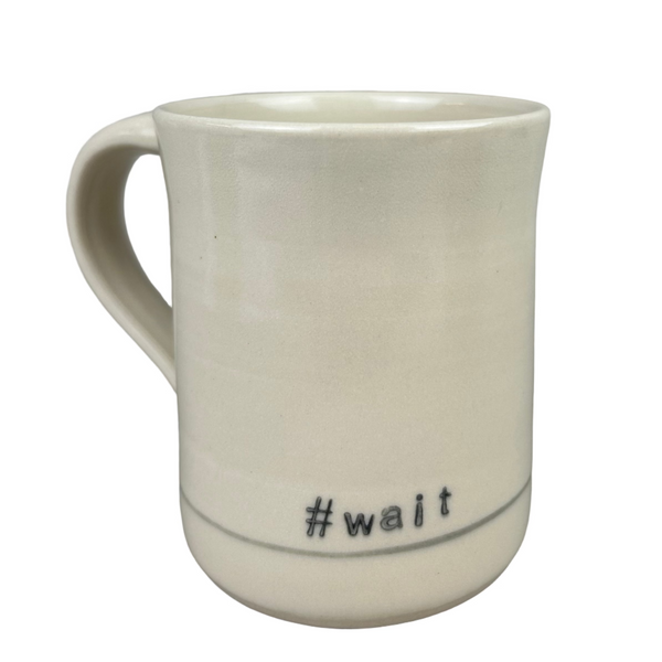 White ceramic mug with '#wait' text on a gray background