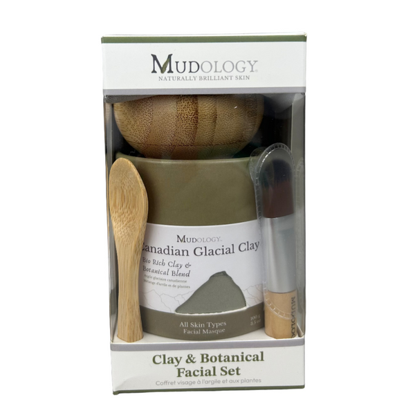 Mudology facial set with a jar, brush, and spoon in packaging on a gray background