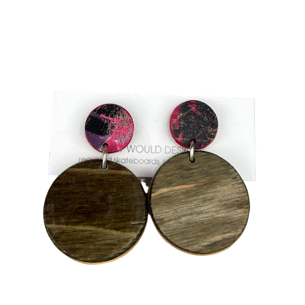 Wooden circle earrings with pink and black accents on a gray background