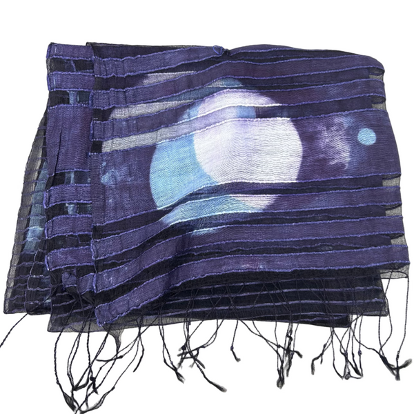 Blue and black scarf with fringe on a white surface