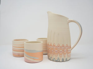 Set of ceramic pitchers with wavy pattern on a white background
