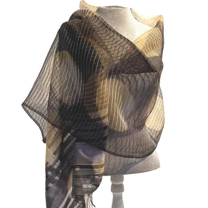 Black and beige patterned scarf on a mannequin against a white background